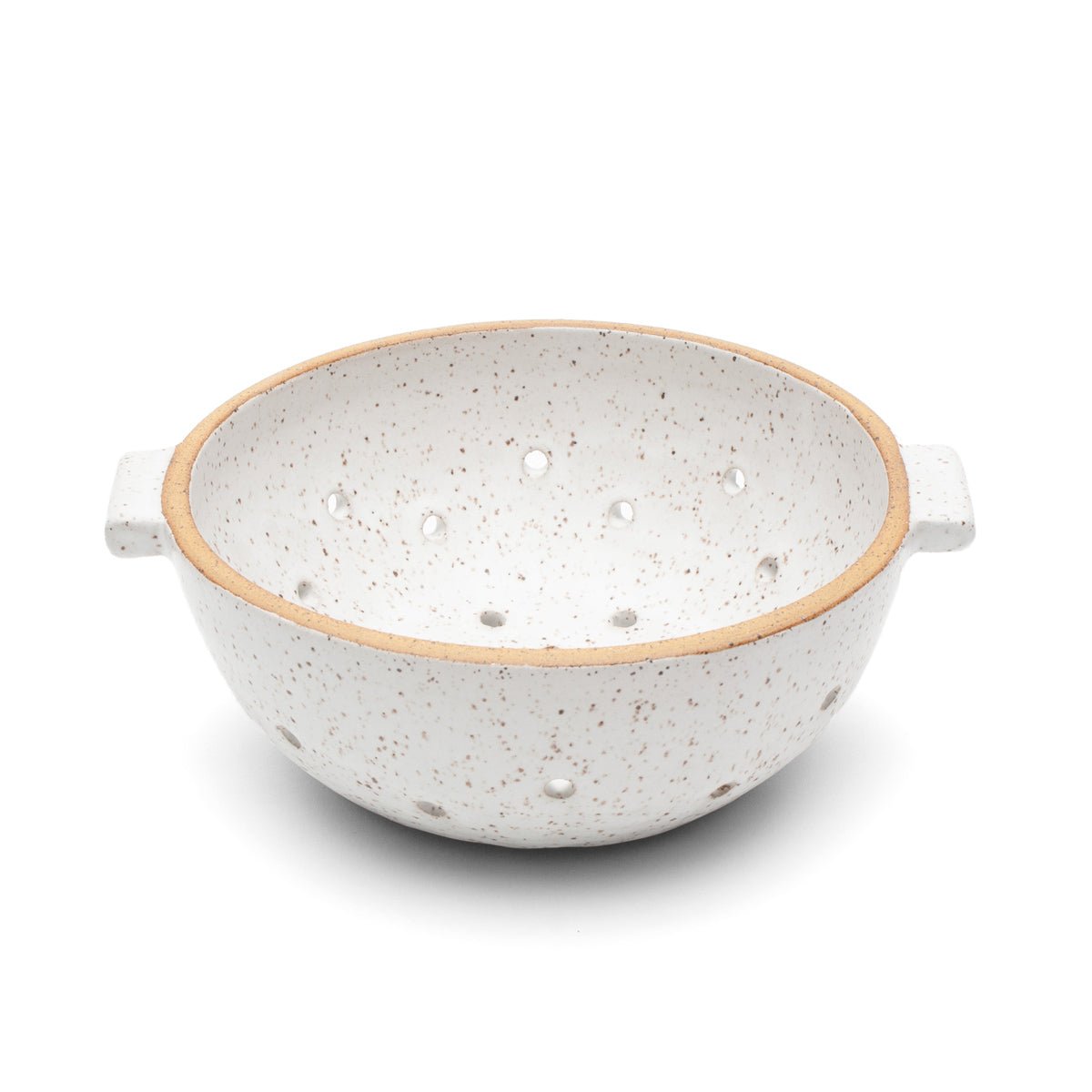 Speckled ceramic colander glazed in a matte white finish with an exposed natural clay edge. The White Colander is designed and handmade by Byun Ceramics in Portland, OR.