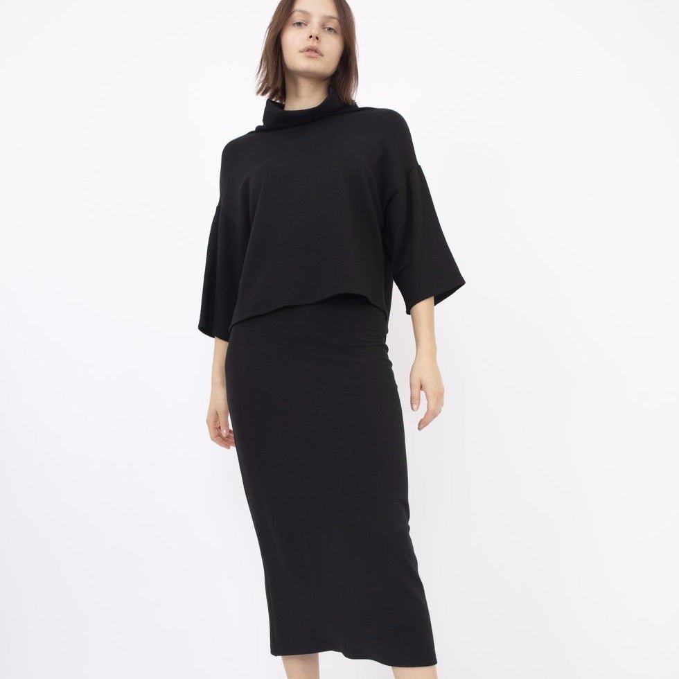 Black high waisted midi skirt with an elastic waistband. The Bailey Skirt in Black is designed by Corinne and made in Los Angeles, CA.