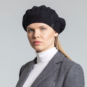 Model wears slouch style hat with a fitted ribbed collar. The Merino Beret in Black is designed by Dinadi and hand knitted in Kathmandu, Nepal.