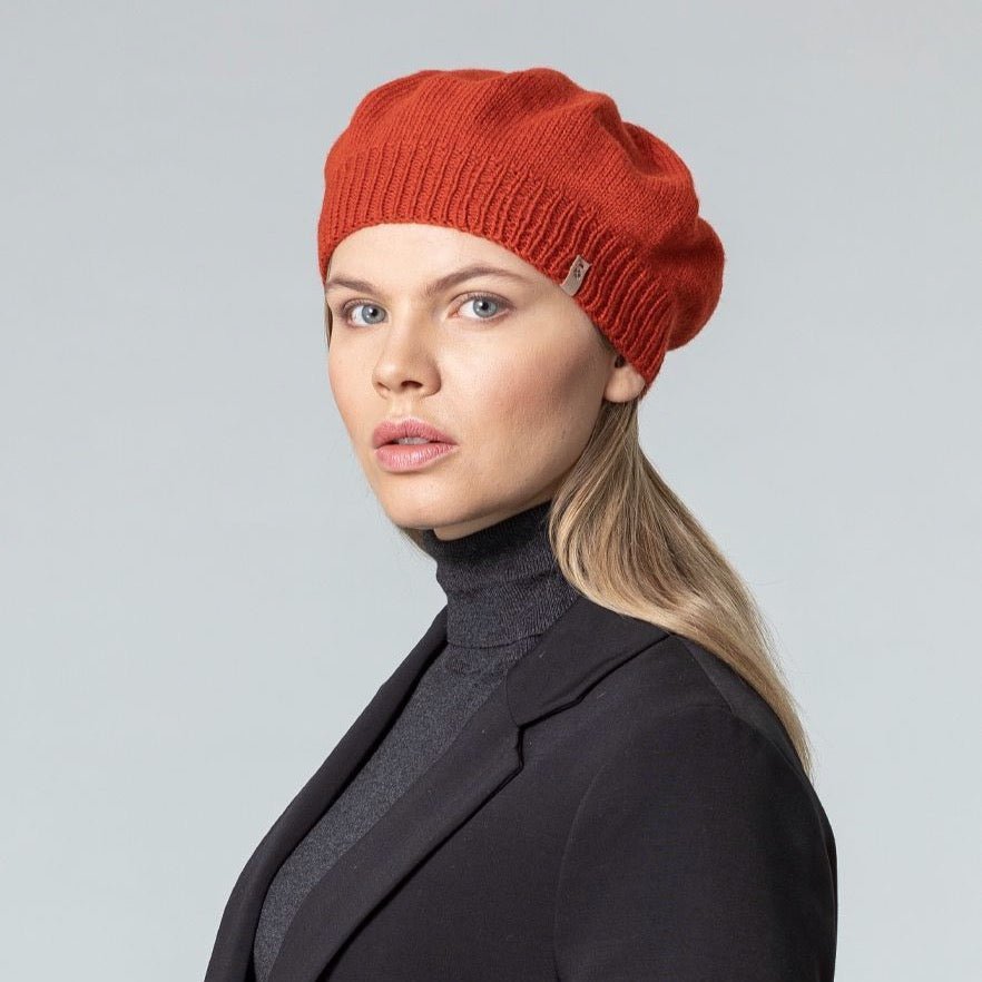 Model wears a slouch style hat with a fitted ribbed collar. The Merino Beret in Burnt Orange is designed by Dinadi and hand knitted in Kathmandu, Nepal.