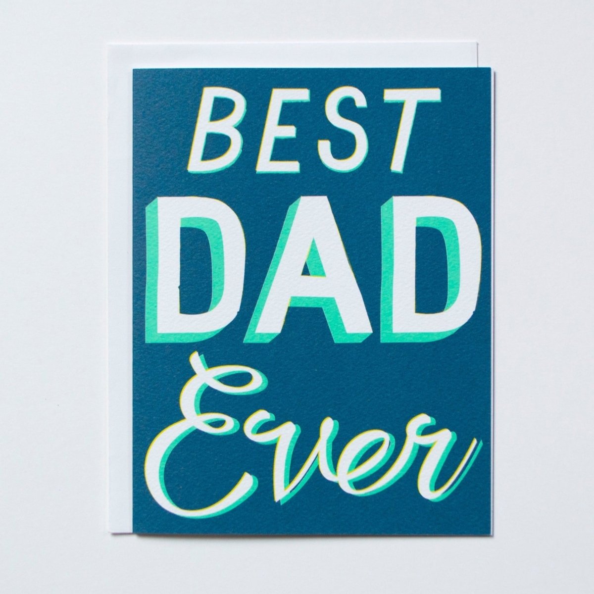 Greeting card reads "BEST DAD EVER" in white and teal script against a blue background. Printed by Banquet Atelier in Vancouver, Canada.