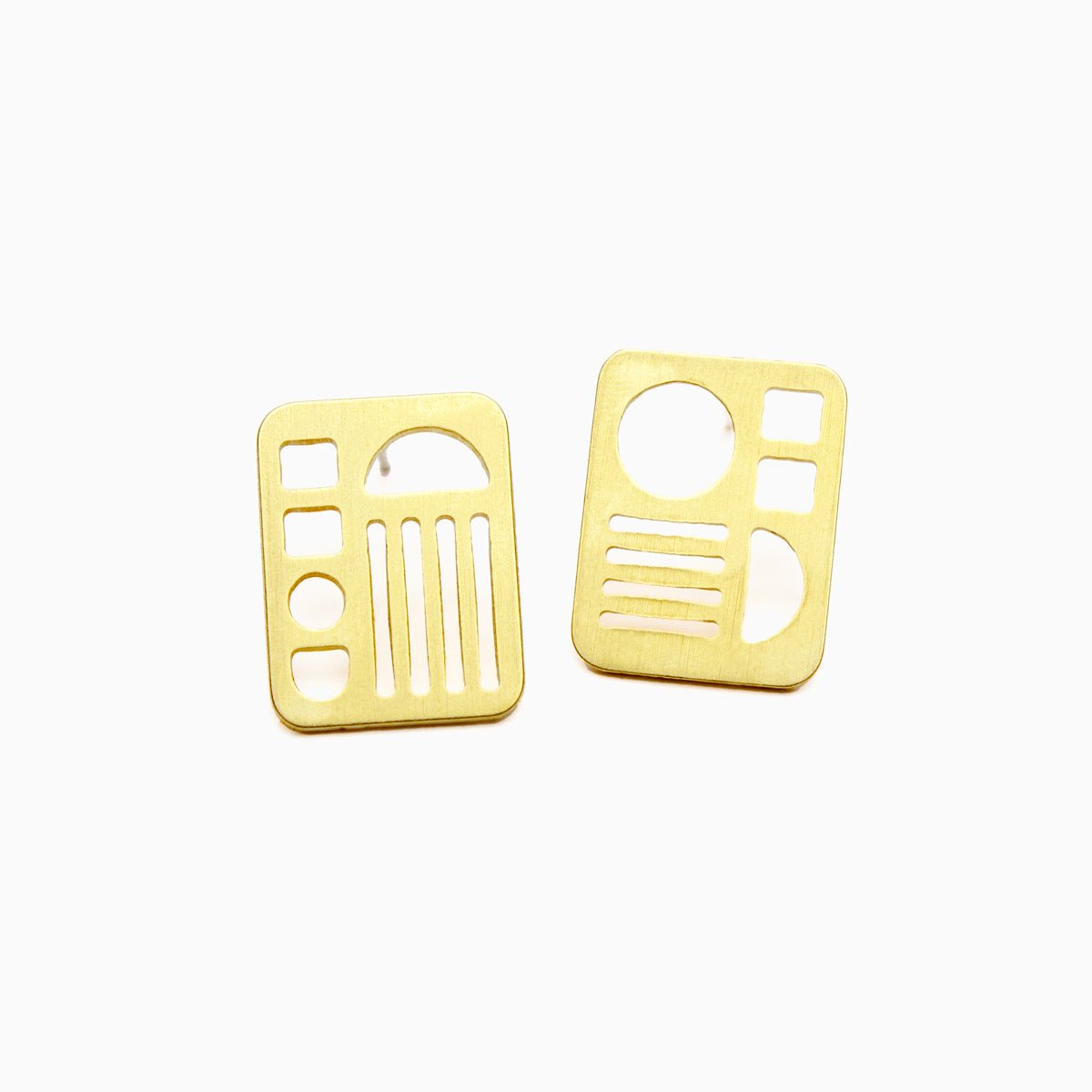 A small brass rectangular stud earring with  circles, lines, squares and half moon cut outs. Designed and handcrafted in Portland, Oregon.