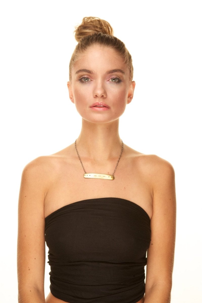 A model wears a customized betsy and iya morse code necklace.