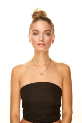 A model wearing a long simple betsy & iya necklace.