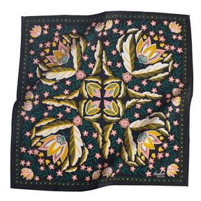 Dark blue bandana with mirror images of green, white, pink and yellow floral pattern. Designed by Hemlock Goods in Fulton, MO and screen printed by hand in India.