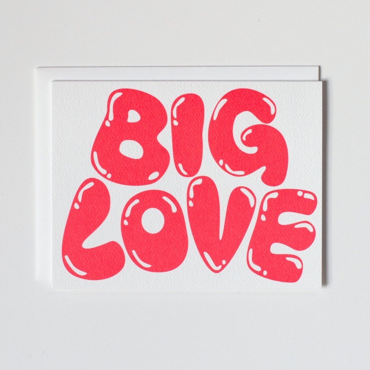 A white greeting card with red/pink bubble letters. Front of card reads: "BIG LOVE." Made with recycled paper by Banquet Atelier in Vancouver, British Columbia, Canada.