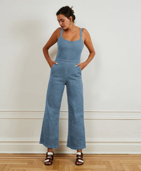  A light blue denim jumpsuit with narrow straps, flared bottom and zipper up the front. The Billy Jumpsuit in Light Indigo is designed by Loup and made in New York City, USA.