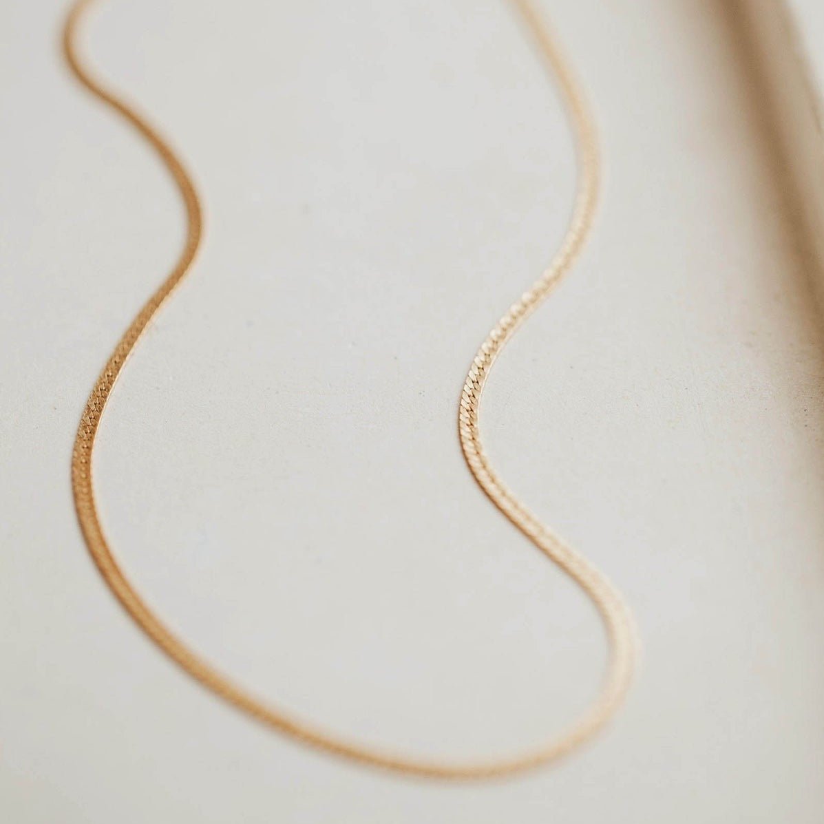 A classic gold tone herringbone necklace. The Bold Herra Necklace is handcrafted by Hello Adorn in Eau Claire, WI.