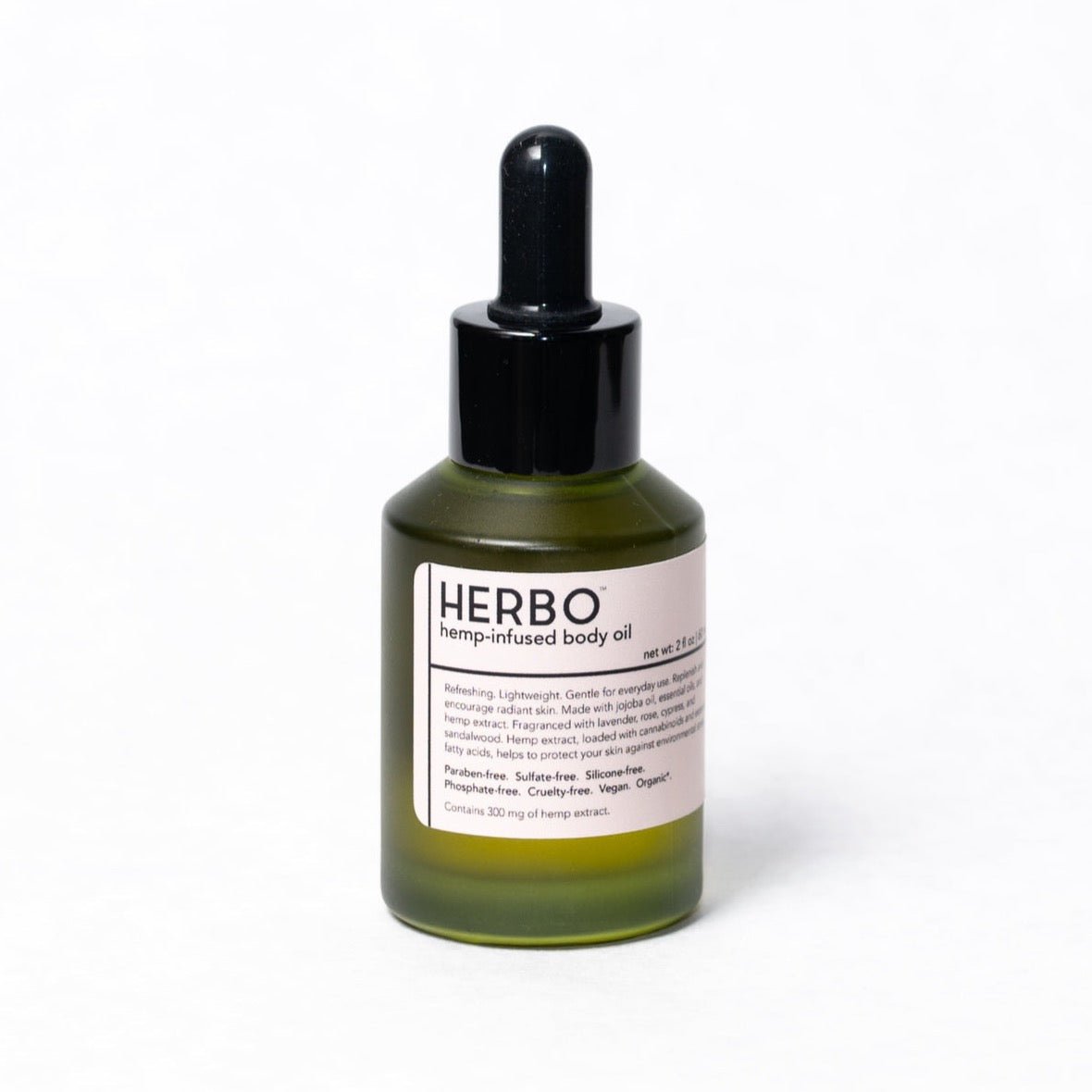A glass olive colored bottle with a black dropper lid filled with hemp-infused body oil. The HERBO Botanical Body Oil is  developed by HERBO in Portland, OR.