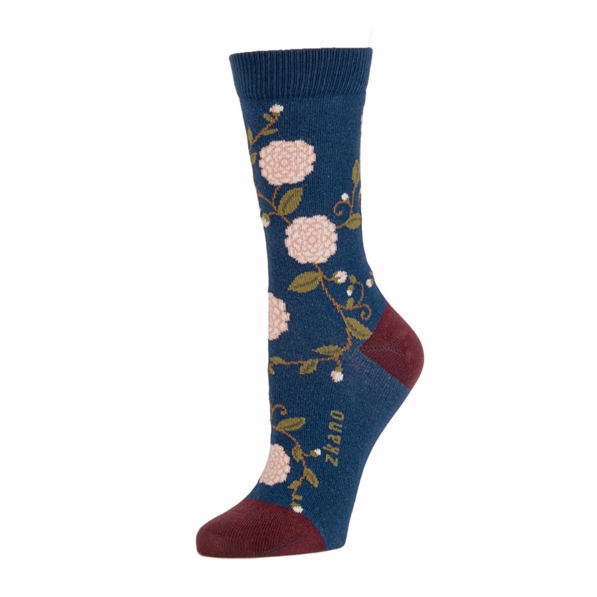 Dark blue sock with light pink and green floral pattern as well as a maroon colored heel and toe accent. The Camilla Floral Crew Sock in Blue Jean is from Zkano and made in Alabama, USA.