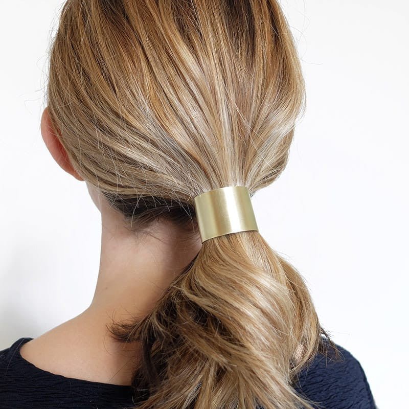 Curved metal ponytail holder in brass