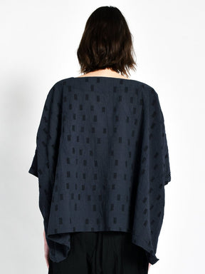 Model shows backside of navy blue oversized tunic with black square pattern. Designed and sewn by UZI in Brooklyn, New York.