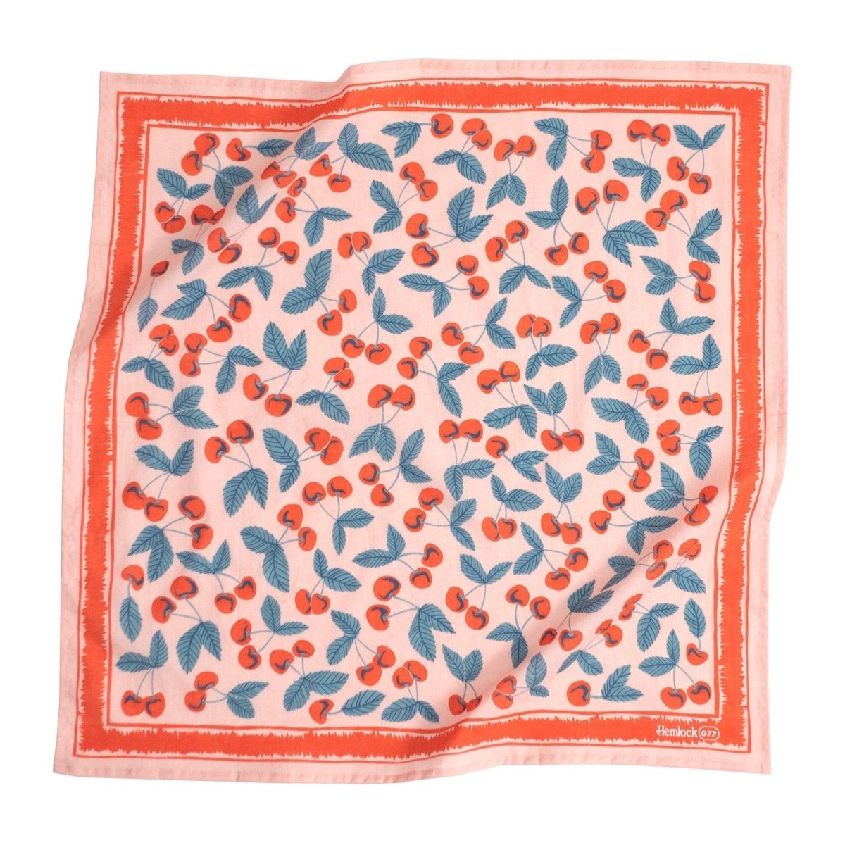 A light pink bandana with bright red and blue cherry illustrations and a solid red border. Designed by Hemlock Goods in Fulton, MO and screen printed by hand in India.
