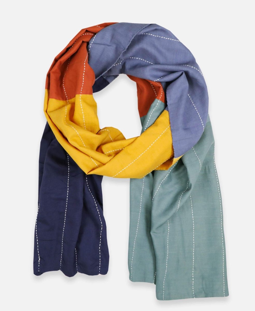 A navy, rust, yellow, slate and spruce colored oversized scarf with white stitching. The Colorblock Scarf in Rainbow is designed by Anchal in Louisville, Kentucky and made in Ajmer, India.