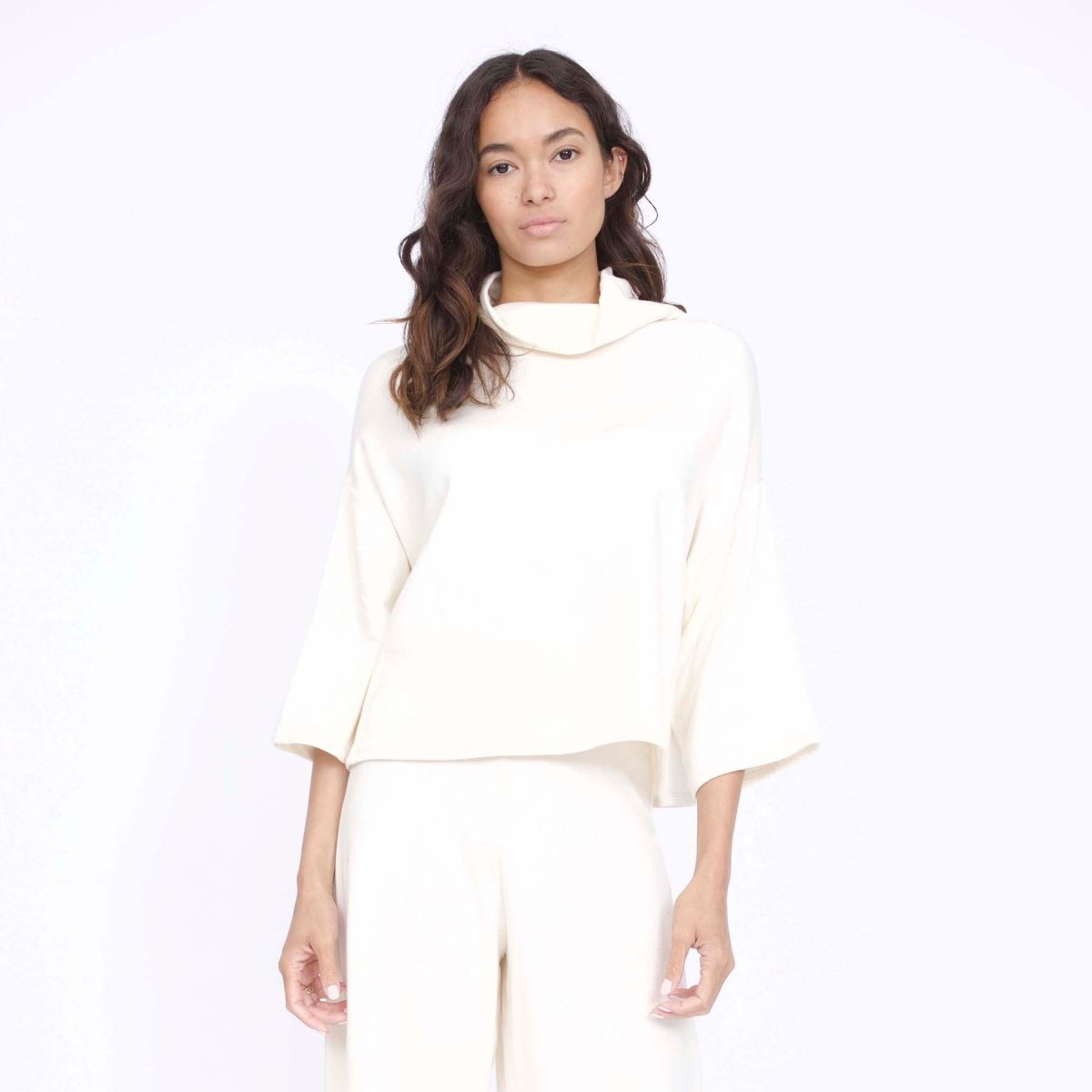 Loose fitting top with 3/4 sleeve and draped neck. The Bucket Sweater in Ivory is designed by Corinne and made in Los Angeles, CA.