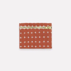 Square cross-stitch coin purse in the color Rust. Designed by Anchal in Louisville, Kentucky and made in Ajmer, India.