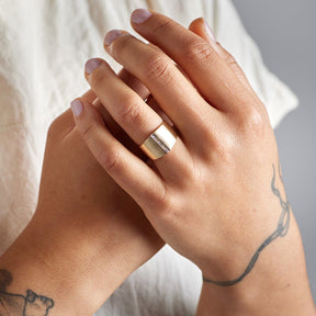 Model wears the Decus ring on their left hand.