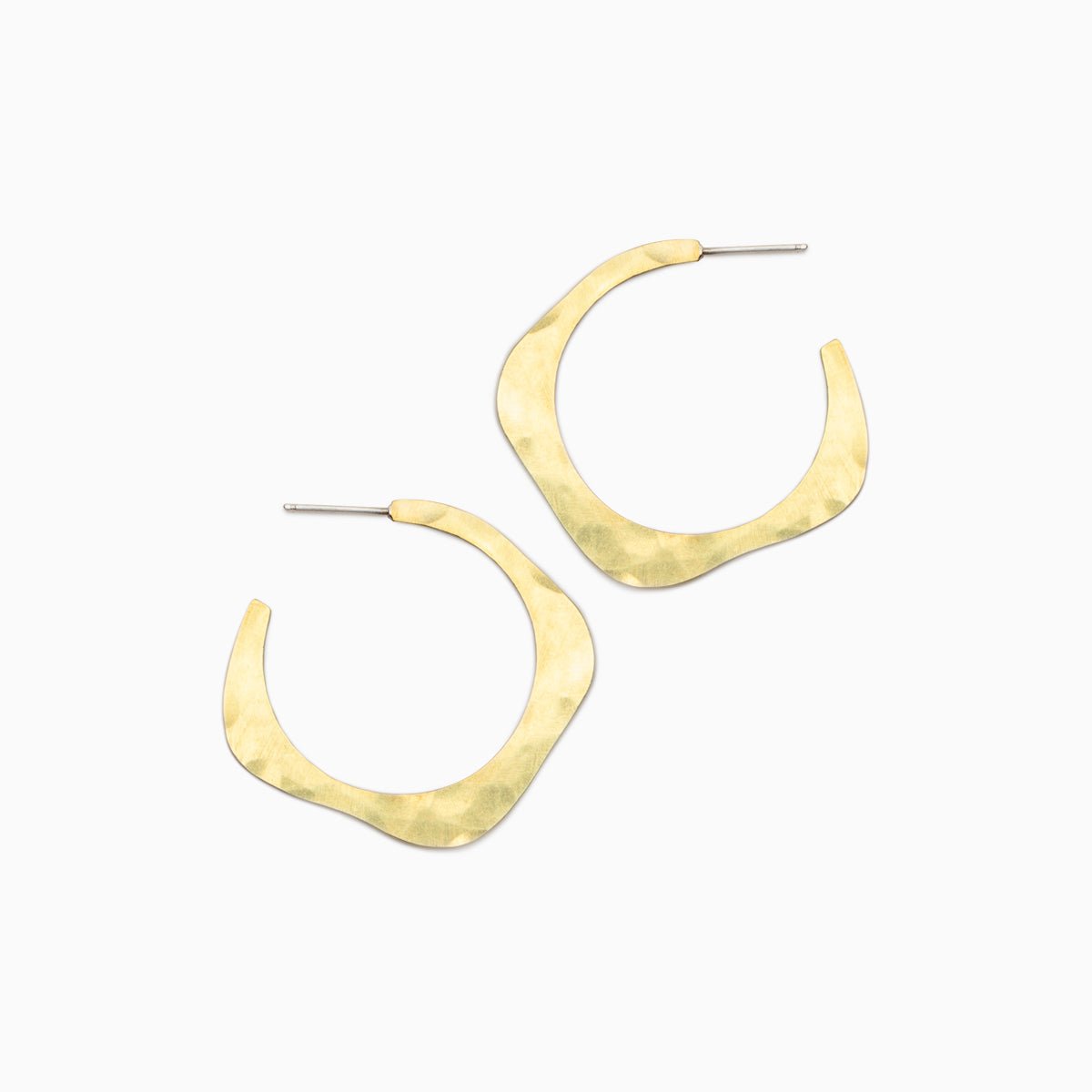 A brass hoop earring in a wave design with a hand hammered texture and sterling silver earring posts. The small Doble Hoop Earrings are designed and handcrafted in Portland, Oregon.