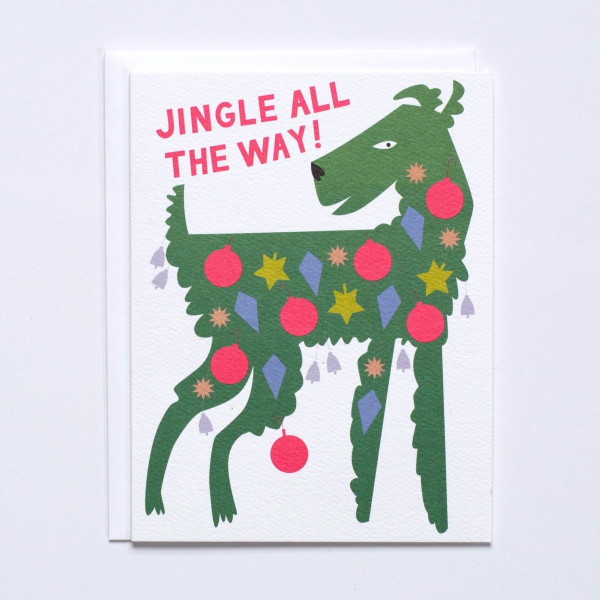 Green dog covered in ornaments in various holiday shapes against a white background. Front of card reads: "JINGLE ALL THE WAY!" Made with recycled paper by Banquet Atelier in Vancouver, British Columbia, Canada.