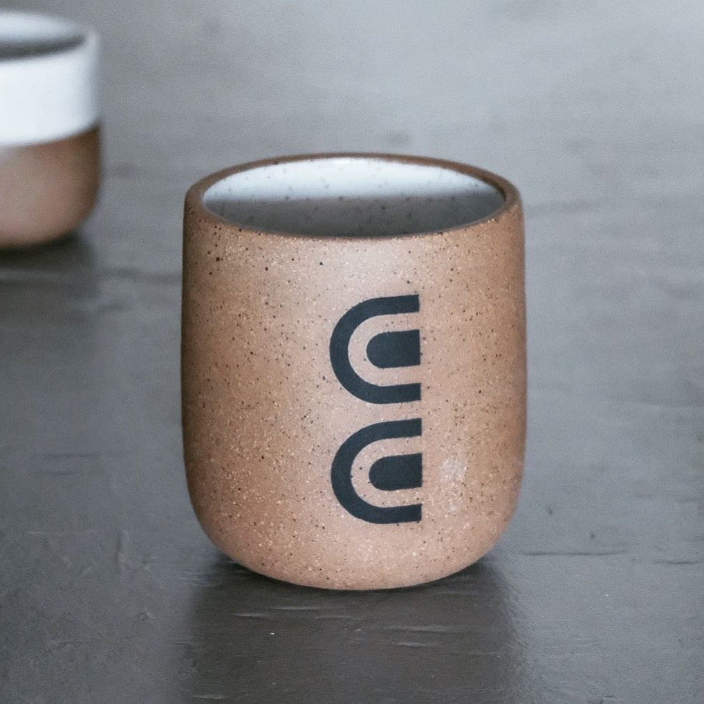 Speckled stoneware cup with painted black arches. Inside is glazed with white satin. Designed and hand thrown by Wolf Ceramics in Hood River, Oregon.