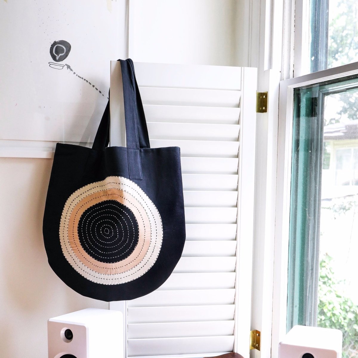 Hanging black tote with cross-stitched circular pattern. Designed by Anchal and handmade in Ajmer, India.