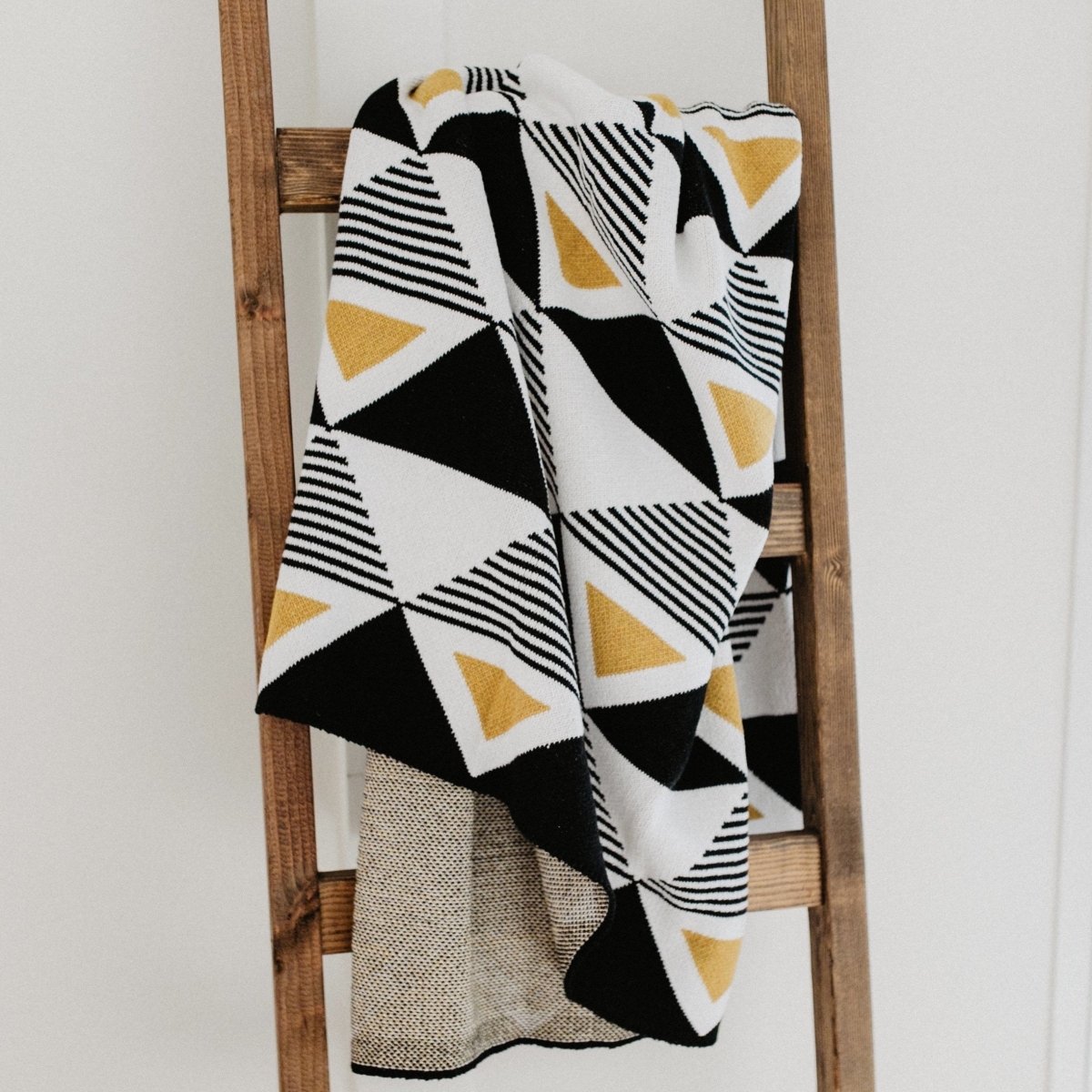 A black, yellow and white geometric patterned throw blanket. Designed by Seek & Swoon in Portland, OR and made in the USA.