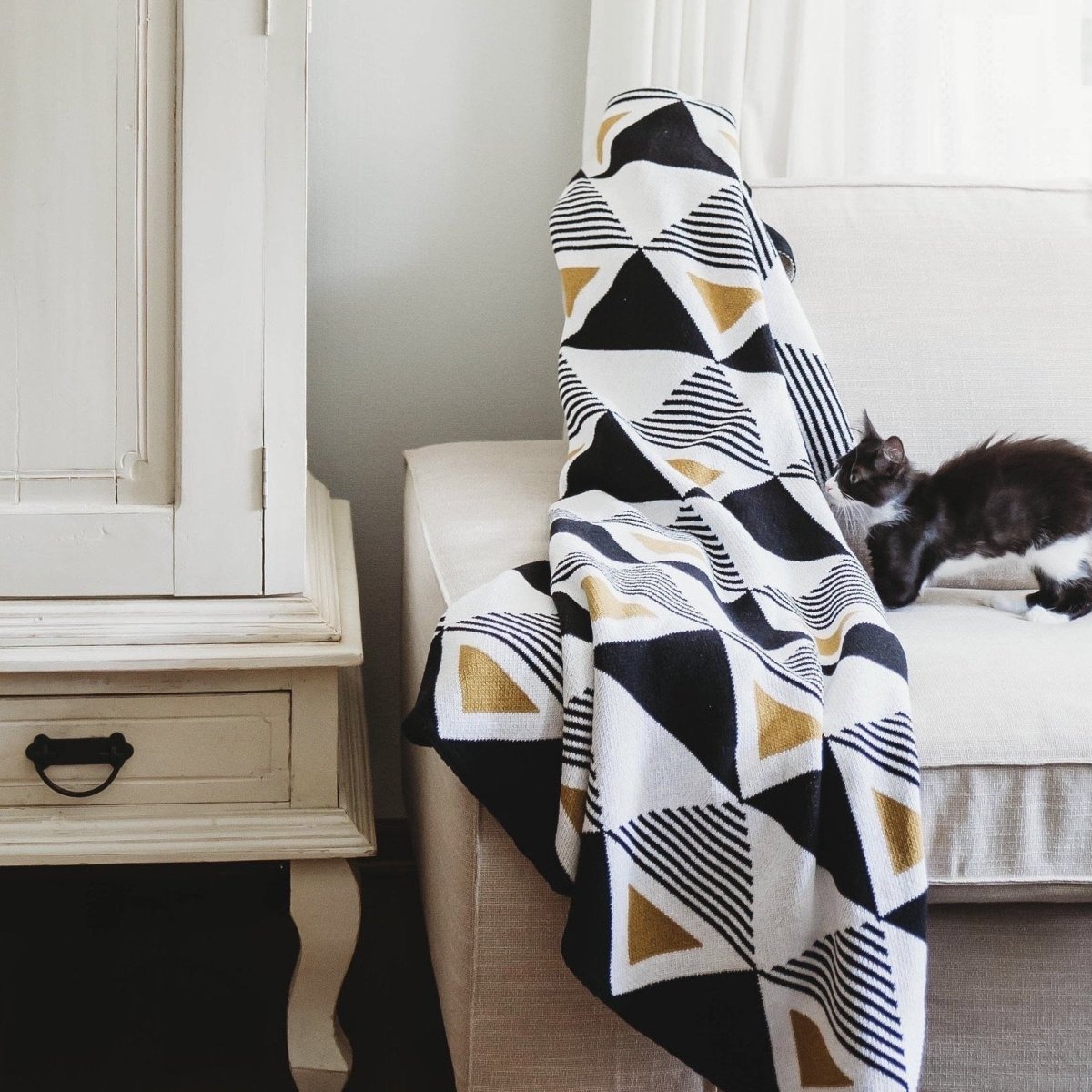 A black, yellow and white geometric patterned throw blanket. Designed by Seek & Swoon in Portland, OR and made in the USA.