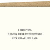 Kraft card with black text that reads: "I MISS YOU. NOBODY HERE UNDERSTANDS HOW HILARIOUS I AM." Comes with a brown Kraft envelope. Designed by Sapling Press and made in Pittsburgh, PA.