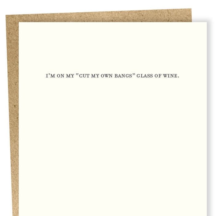Kraft card with black text that reads: "I'M ON MY 'CUT MY OWN BANGS' GLASS OF WINE." Designed by Sapling Press and printed in Pittsburgh, PA.