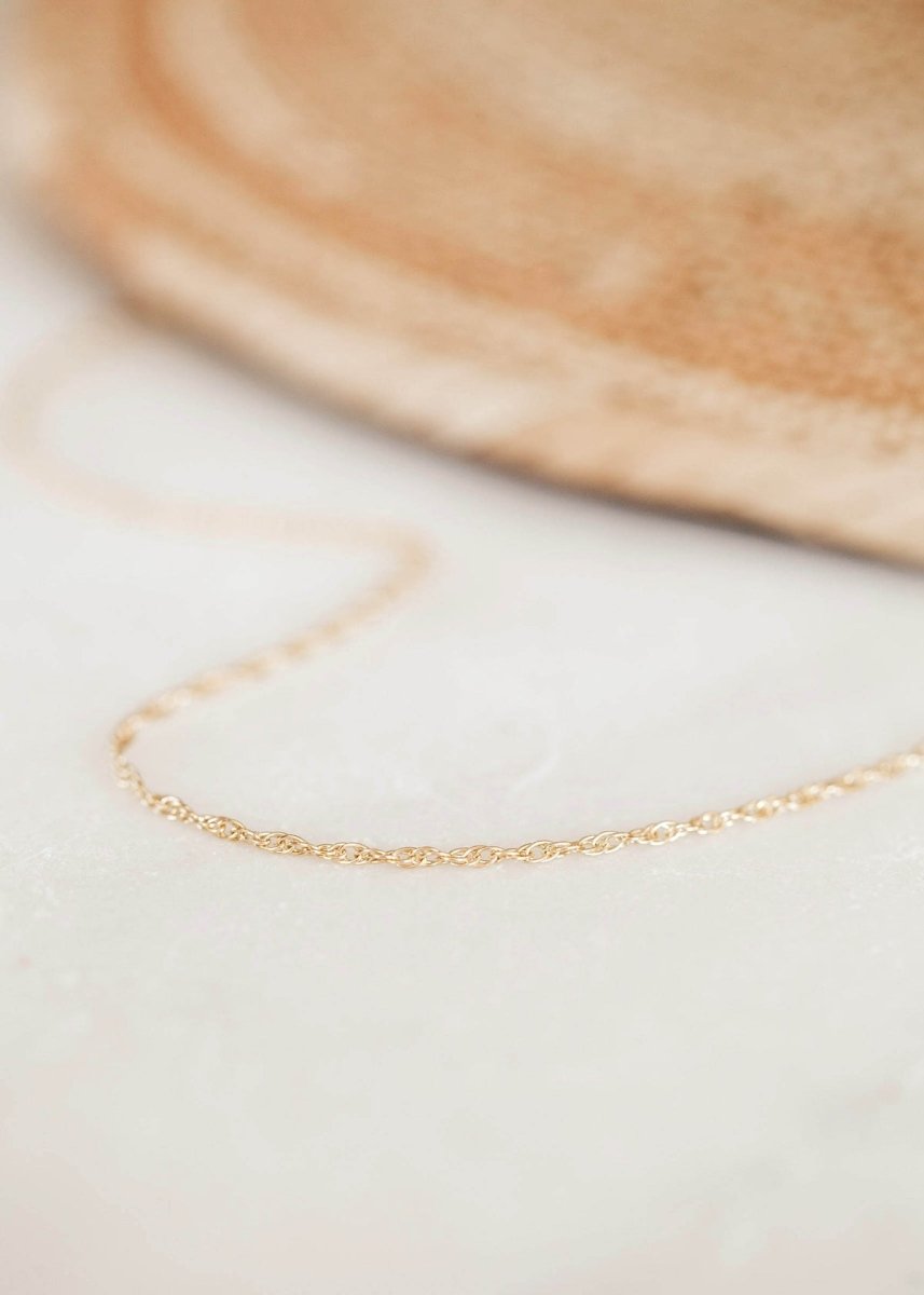 A gold tone rope chain necklace. The Goldie Necklace is handcrafted by Hello Adorn in Eau Claire, WI.