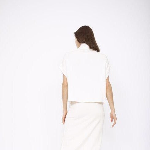 A draped short sleeve top with a slouchy mock neck in Ivory. Fabric and top made in Los Angeles, CA by Corinne Collection.