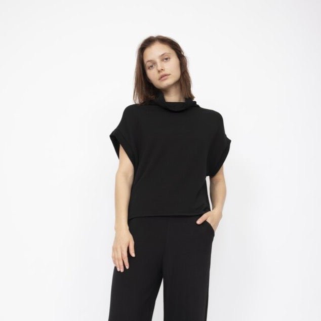 A draped short sleeve top with a slouchy mock neck in Black. Fabric and top made in Los Angeles, CA by Corinne Collection.