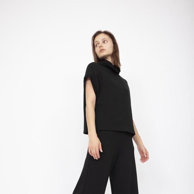 A draped short sleeve top with a slouchy mock neck in Black. Fabric and top made in Los Angeles, CA by Corinne Collection.