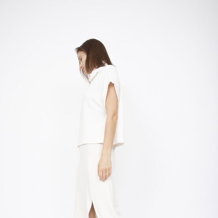 A draped short sleeve top with a slouchy mock neck in Ivory. Fabric and top made in Los Angeles, CA by Corinne Collection.