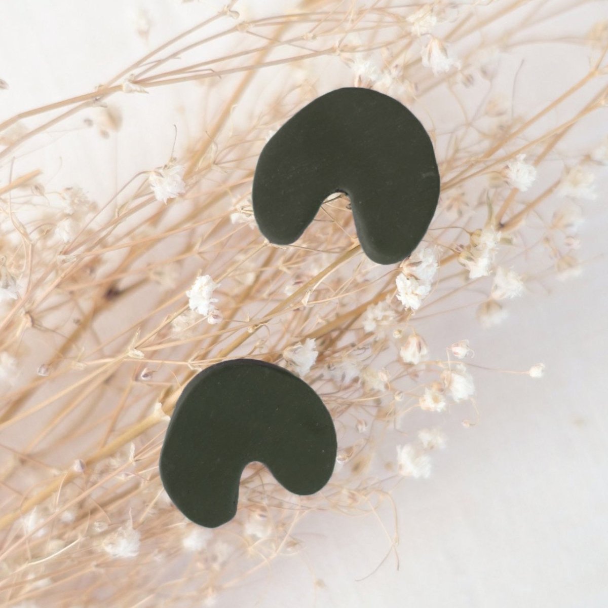 Arch shaped stud earrings made of polymer clay in the shade Aurora Green. Made in Los Angeles, California by Hey Moon Designs.