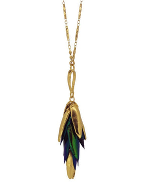 Brass chain connected to brass wing-like shapes and blue and green beetle wings. The I Can See the Light necklace is from designer Lingua Nigra.