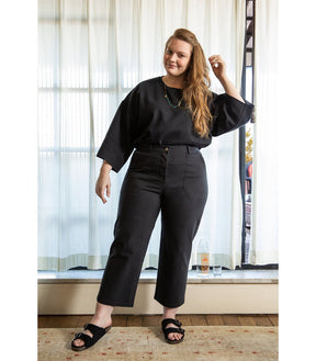 Model wears a straight leg cropped work pant in black. The James Pant in Black is designed by Loup and made in New York City, USA.