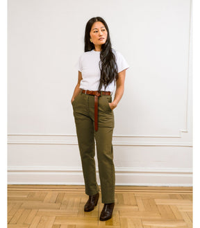 Model wears a straight leg cropped work pant in an army green. The James Pant in Moss Green is designed by Loup and made in New York City, USA.