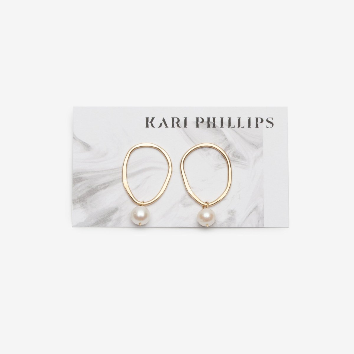 Brass organic oval shaped earrings with a pearl attached at the bottom. Made in Portland by artist Kari Phillips.