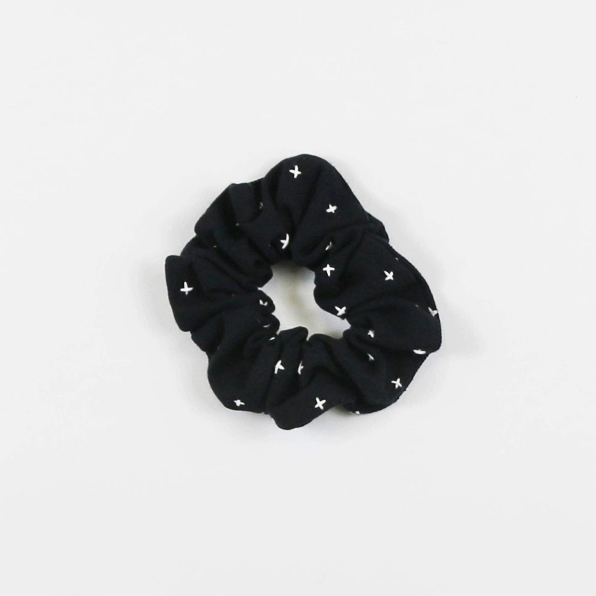 Black cotton canvas scrunch with white stitching. The Kantha Scrunchie in Charcoal is designed by Anchal in Louisville, Kentucky and handmade in Ajmer, India.
