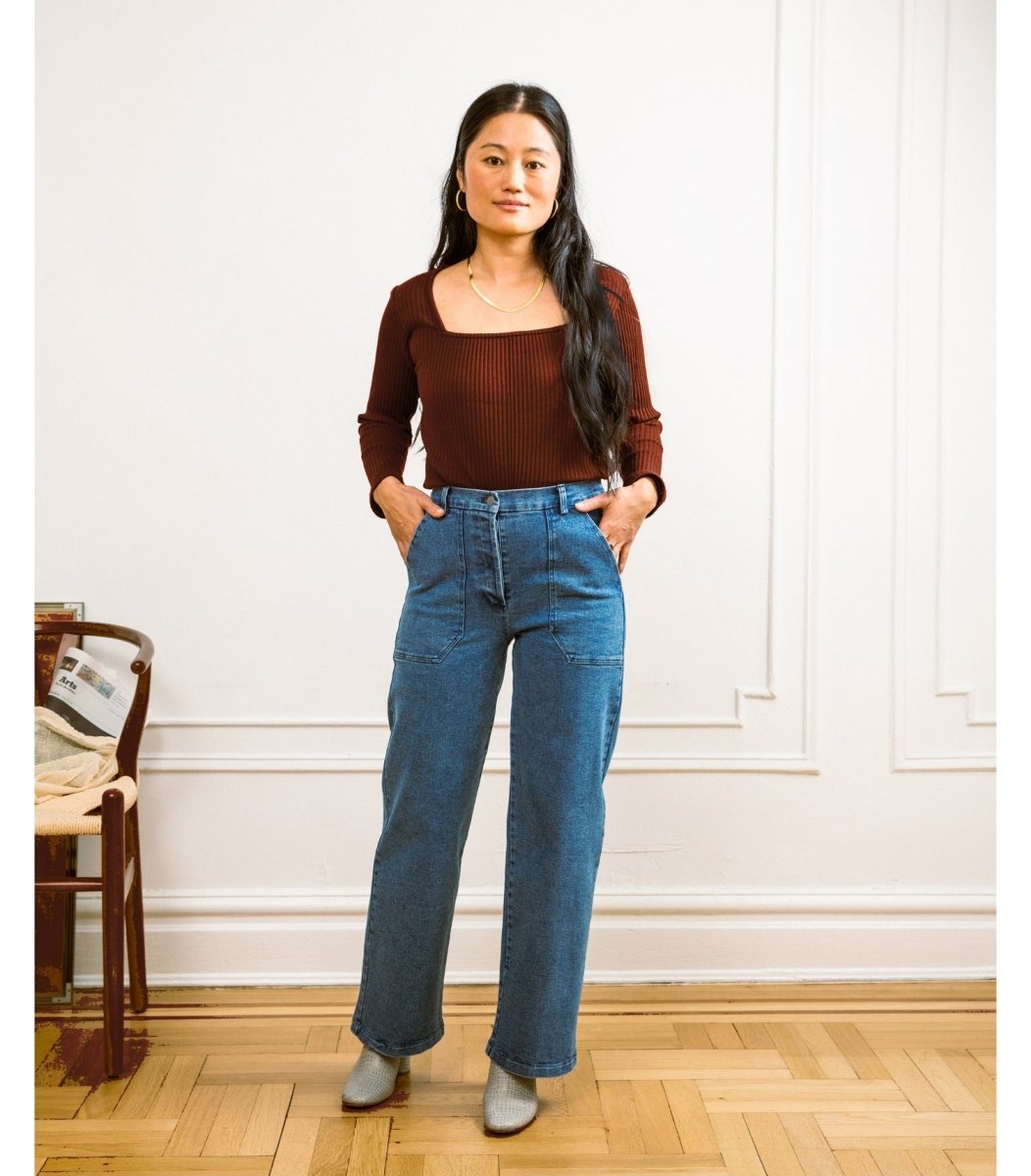 A model wears a high waisted wide leg crop jean in a blue denim. The Kate jean in Medium Indigo are designed by Loup and made in New York City, USA.