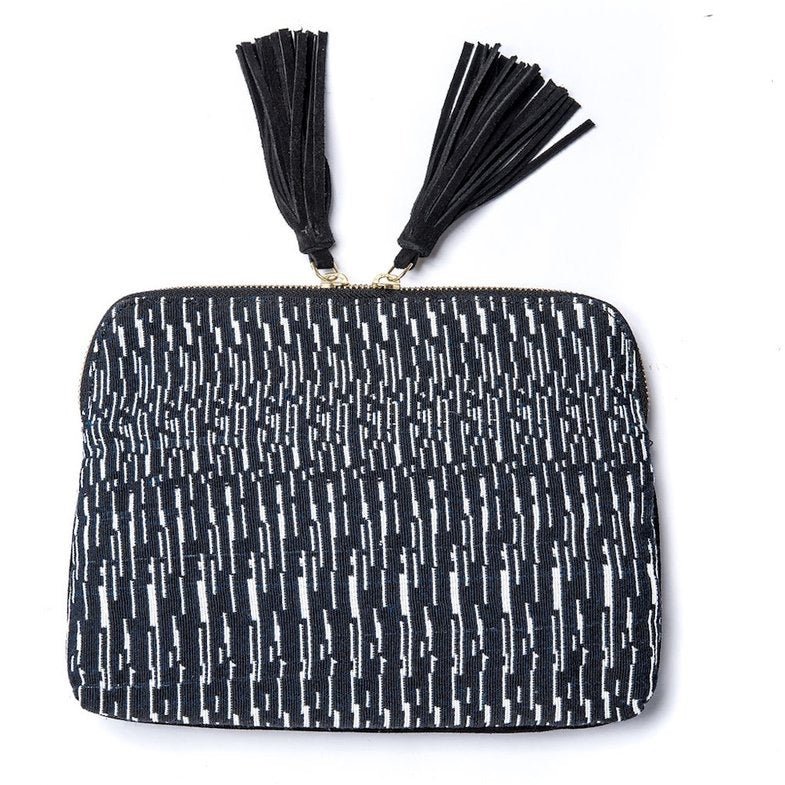 Black and white patterned clutch with two suede leather tassels and zip closure. Clutch is hand-loomed from Bloom & Give.
