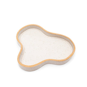 A speckled matte white blob tray with a raw clay edge. The Blob Tray in White is designed and handmade by Kohai Ceramics in Portland, OR.