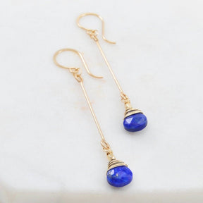 Lapis teardrops wrapped in blackened sterling and golf fill wires hang from a gold fill bar connected by a faceted gold fill bead. The Lapis Bar Drop earrings are designed and handmade by Amy Olson in Portland, Oregon.