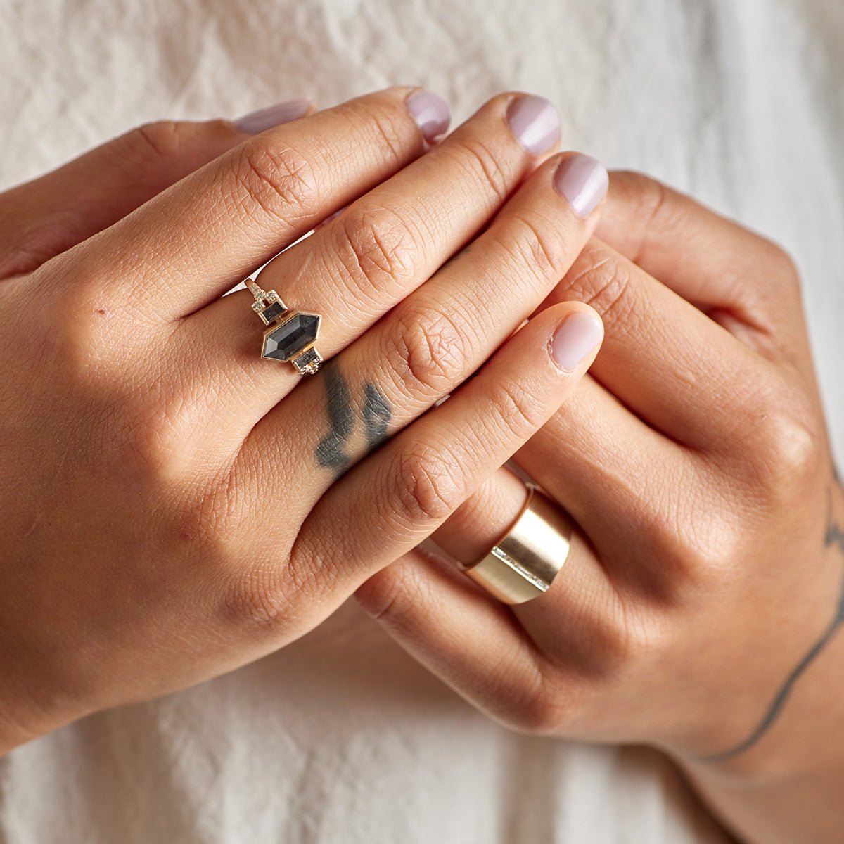 Model wears the Libero ring on their right hand, and the Decus ring on their left hand.