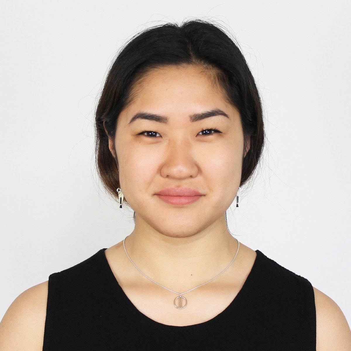 Betsy & iya Liv necklace in cast bronze, styled on a model with a black tank top and dark hair.