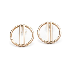Minimal, modern, and shiny cast bronze stud earrings, featuring a small, open circle with two vertical bars running through the center. Hand-crafted in Portland, Oregon.