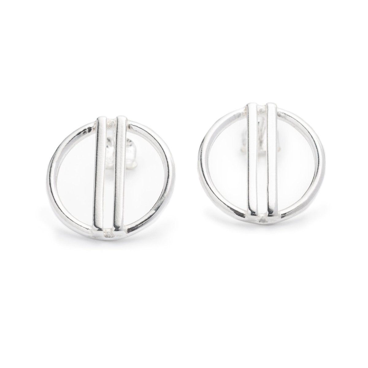 Minimal, modern, and shiny cast silver stud earrings, featuring a small, open circle with two vertical bars running through the center. Hand-crafted in Portland, Oregon.