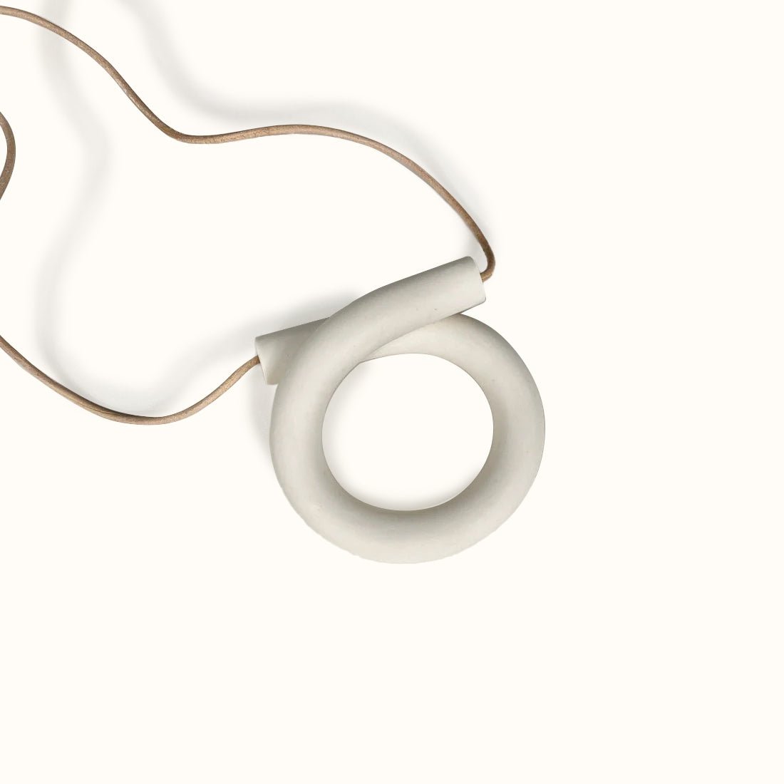 An adjustable statement necklace with an off white polymer clay focal piece in a large loop shape. The Loop Necklace in Cream is designed and handcrafted by Little Pieces Jewelry in Los Angeles, CA.