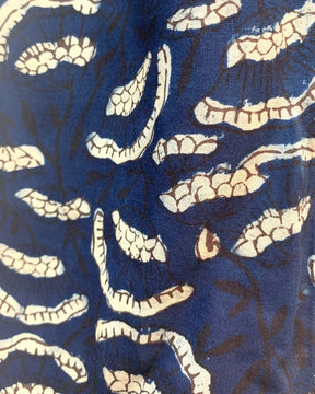 Closeup of a dark blue scarf with cream flowers printed in a pattern. The Oversized Scarf in Etta is from designer Maelu.
